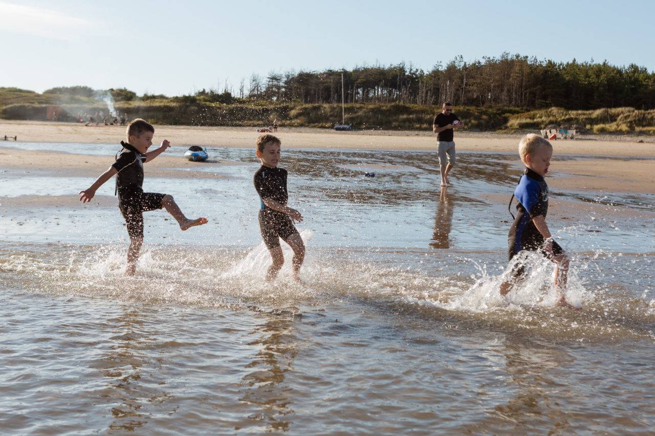 silver-bay-holiday-village-anglesey-busy-bayers-boys-playing-ocean-water-1280x853.jpg
