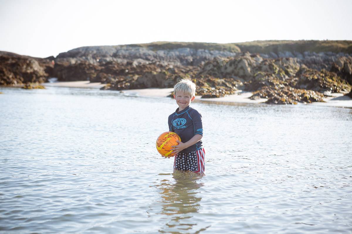 silver-bay-holiday-village-anglesey-young-boy-in-ocean-with-ball.jpg