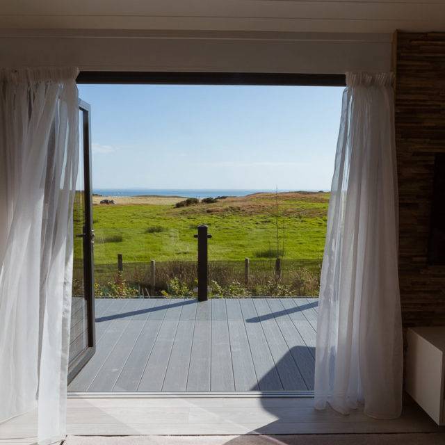 https://bulmerleisure.co.uk/wp-content/uploads/2016/12/silver-bay-holiday-village-luxury-lodges-anglesey-headland-rise-shearwater-the-view-grass-blue-skies-640x640.jpg