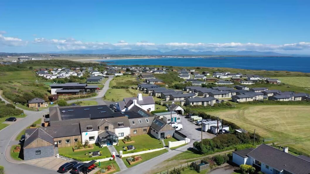 Aerial view over Silver Bay holiday park towards the sea and the mountains beyond
