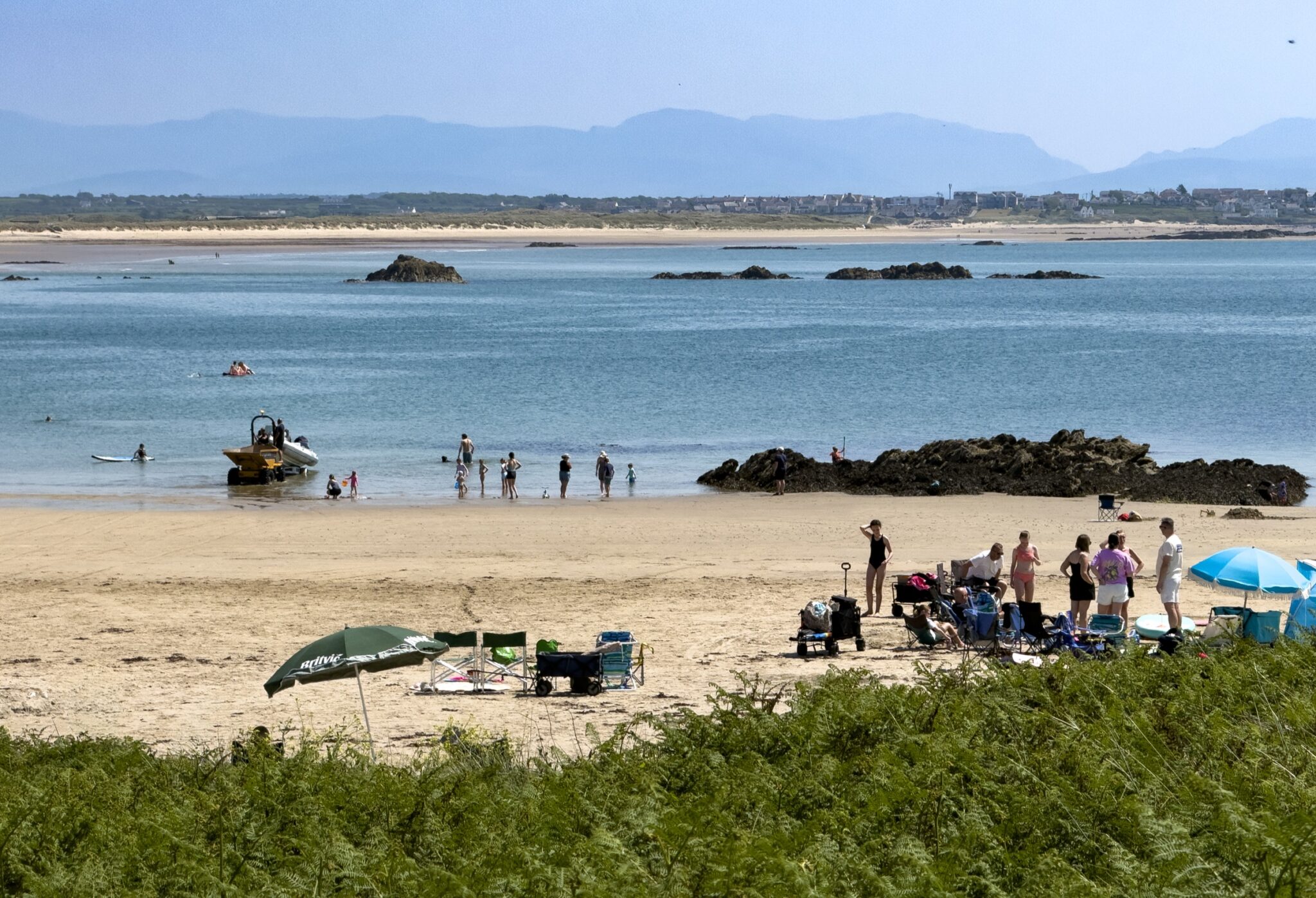 Silver Bay's beach on a summer day, with mountains across the water